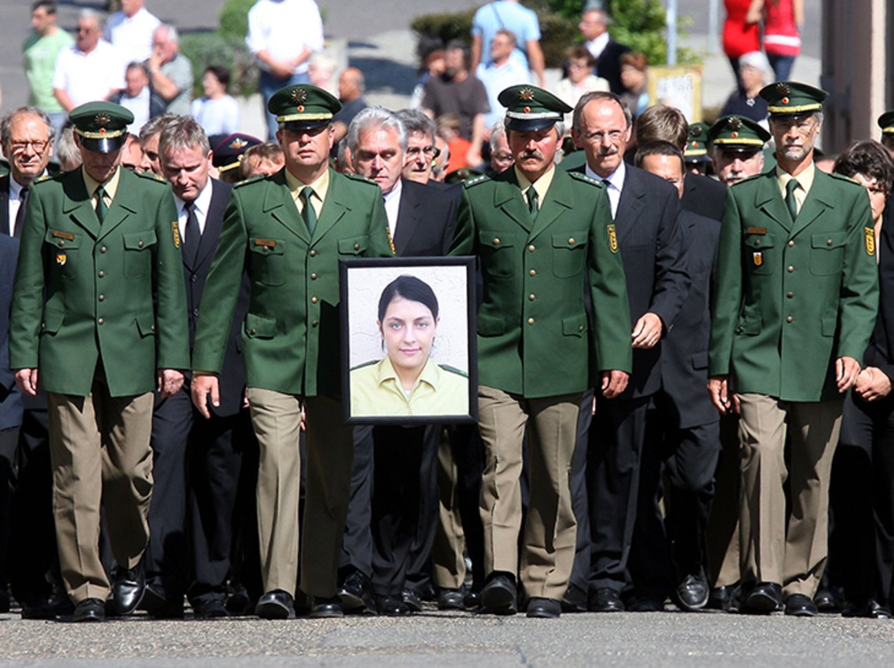 Polizisten tragen bei einem Gedenkmarsch in Böblingen (Baden-Württemberg) das Bild ihrer von der NSU-Terrorgruppe ermordeten Kollegin Michèle Kiesewetter. | Foto: © picture-alliance/ dpa