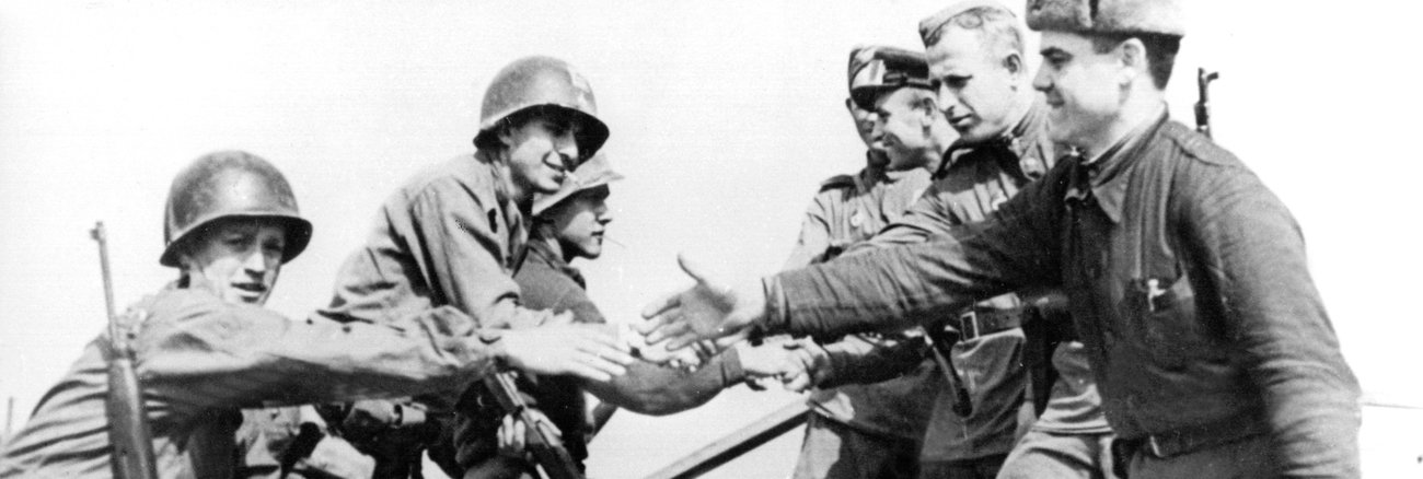 Sowjetische und US-amerikanische Soldaten reichen sich im April 1945 auf den Trümmern einer Elbbrücke bei Torgau die Hände @ dpa Sowjetische und US-amerikanische Soldaten reichen sich im April 1945 auf den Trümmern einer Elbbrücke bei Torgau die Hände @ dpa