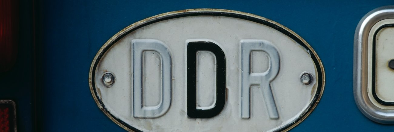 Altes DDR-Kfz-Länderkennzeichen mit dem ersten D und dem R weiß überstrichen @ iStock/clu Altes DDR-Kfz-Länderkennzeichen mit dem ersten D und dem R weiß überstrichen @ iStock/clu