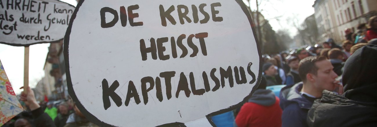 Bei Protesten trägt eine Frau ein Schild mit der Aufschrift »Die Krise heisst Kapitalismus« © Fredrik von Erichsen/dpa Bei Protesten trägt eine Frau ein Schild mit der Aufschrift »Die Krise heisst Kapitalismus« © Fredrik von Erichsen/dpa