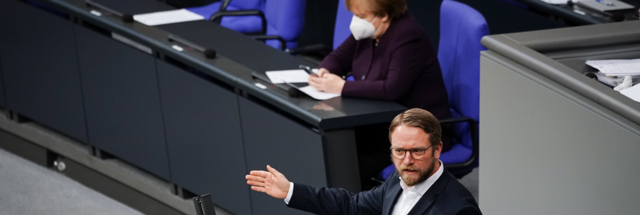 Jan Korte am Rednerpult des Bundestages, dahinter Bundeskanzlerin Merkel auf der Regierungsbank Jan Korte am Rednerpult des Bundestages, dahinter Bundeskanzlerin Merkel auf der Regierungsbank