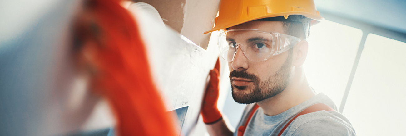 Arbeiter mit Handschuhen, Schutzbrille und Helm © iStock/gilaxia