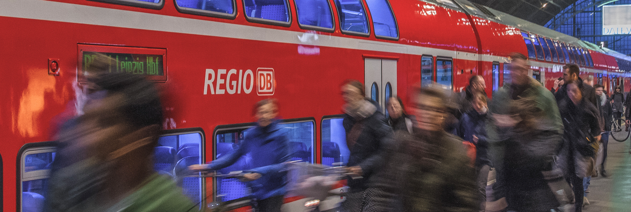Menschen vor einem Regionalexpress der Deutschen Bahn in einem Bahnhof © iStock/kmn-network Menschen vor einem Regionalexpress der Deutschen Bahn in einem Bahnhof © iStock/kmn-network