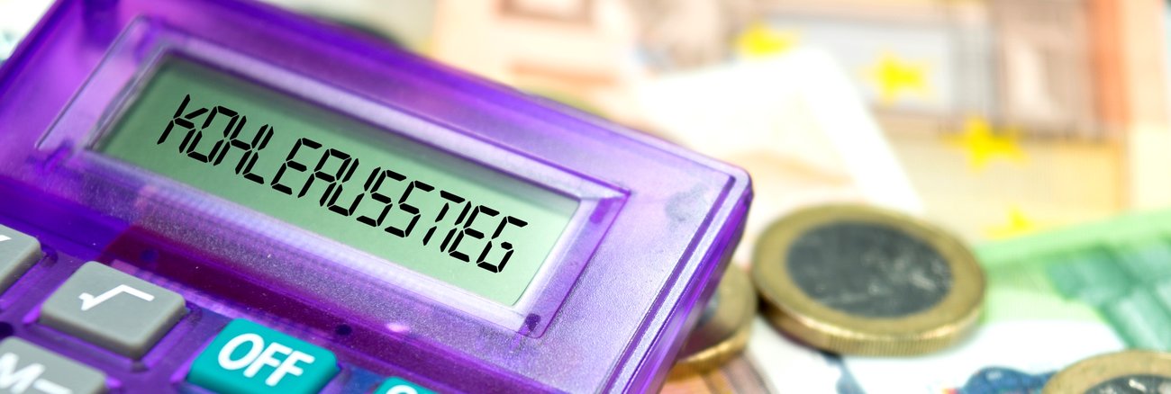 Ein Taschenrechner liegt neben Euroscheinen und -münzen und zeigt im Display Kohleausstieg an © iStock/Stadtratte Ein Taschenrechner liegt neben Euroscheinen und -münzen und zeigt im Display Kohleausstieg an © iStock/Stadtratte