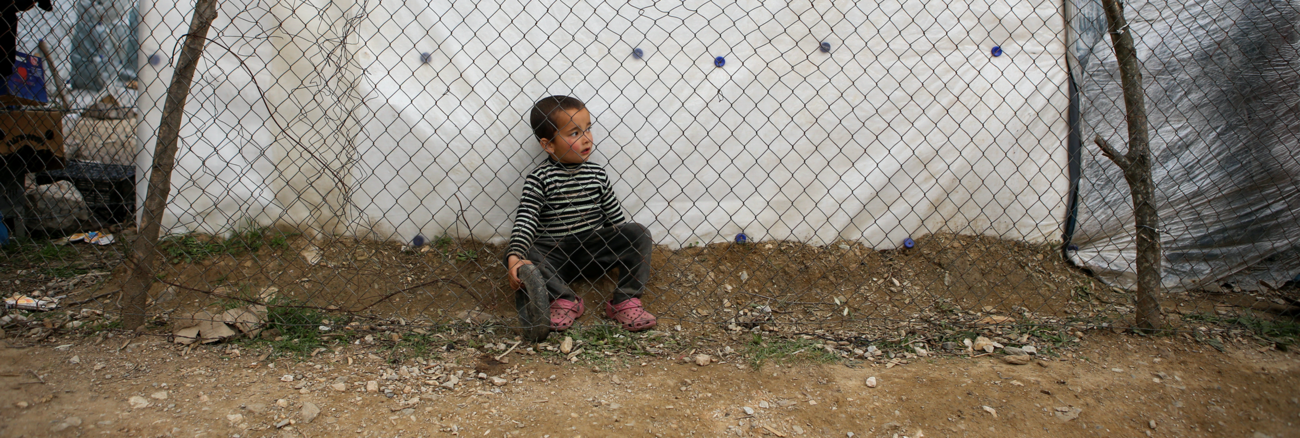 Ein Flüchtlingsjunge sitzt hinter einem Gitterzaun im Lager Moria auf der griechischen Insel Lesbos © REUTERS/Elias Marcou Ein Flüchtlingsjunge sitzt hinter einem Gitterzaun im Lager Moria auf der griechischen Insel Lesbos © REUTERS/Elias Marcou