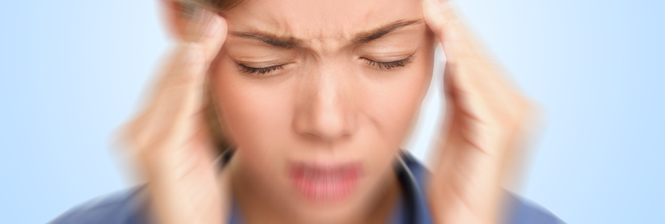 Eine Frau hält sich mit von Schmerz gezeichnetem Gesichtsausdruck die Fingerspitzen an die Schläfen. | Foto: © istock.com/Maridav Eine Frau hält sich mit von Schmerz gezeichnetem Gesichtsausdruck die Fingerspitzen an die Schläfen. | Foto: © istock.com/Maridav